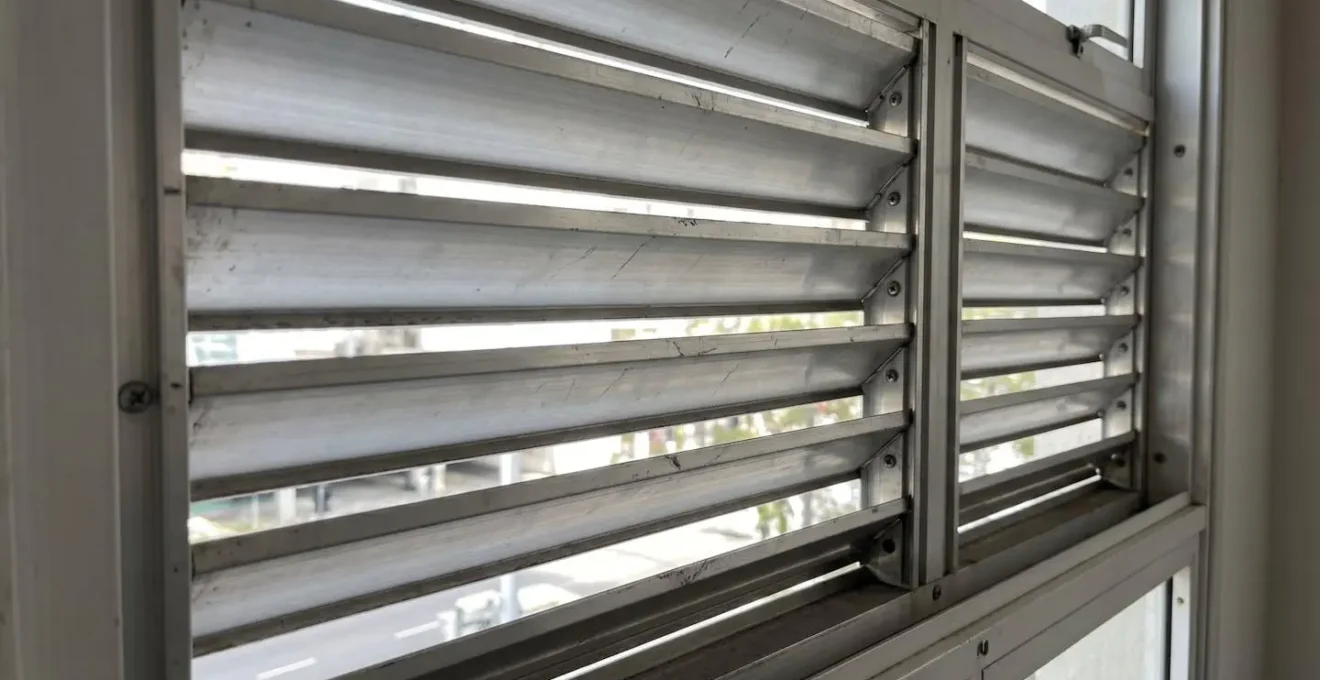 Gros plan sur des lames fixes en aluminium avec espacement visible entre les lamelles laissant passer la lumière naturelle